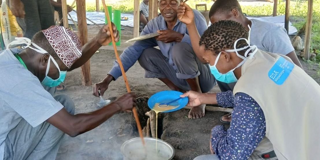Activista e técnica da APDS preparam papas enriquecidas ao lume